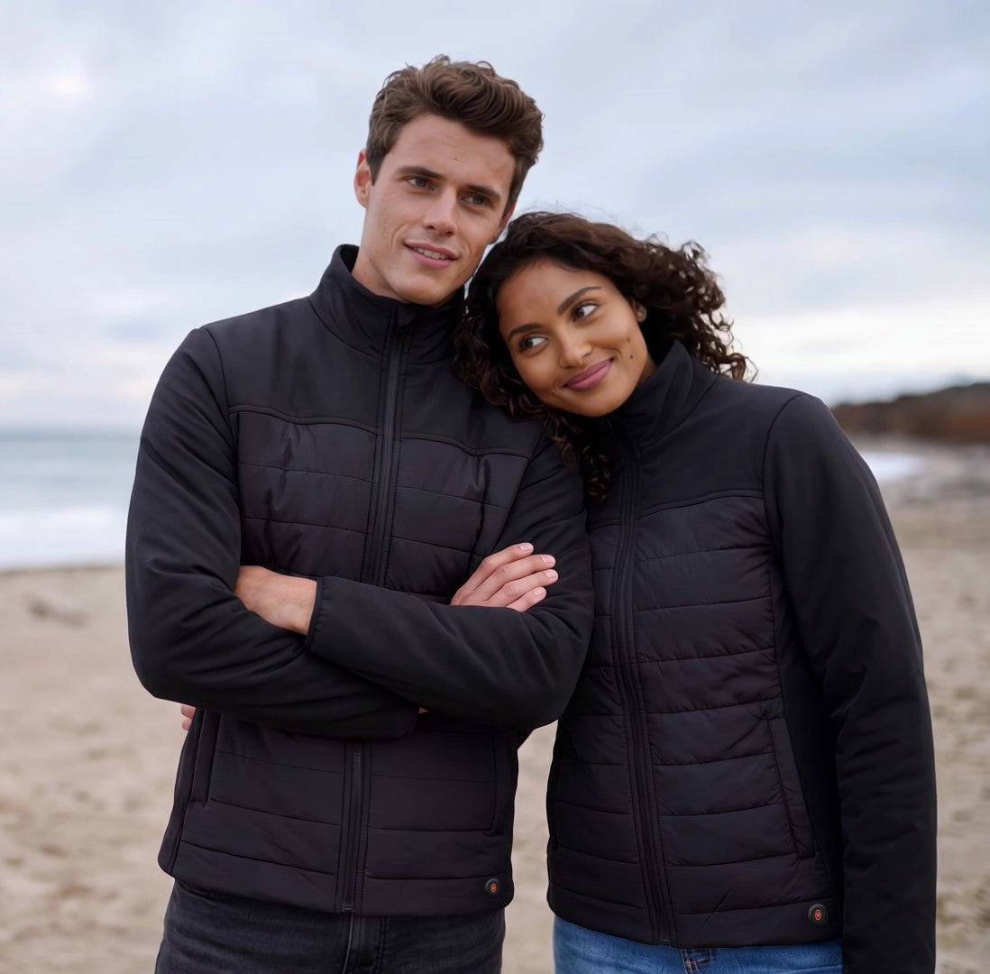Couple sur la plage portant des manteaux chauffants Sagney noirs